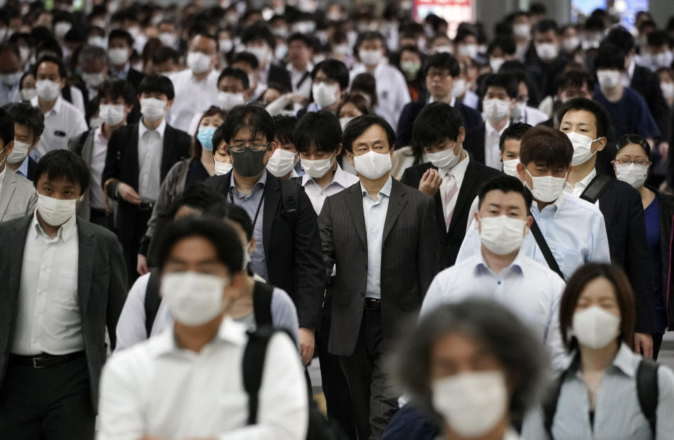 A station passageway is crowded with commuters wearing face mask during a rush hour Tuesday, May 26, 2020, in Tokyo. Japan has kept its deaths from the new coronavirus low despite a series of missteps that beg the question of whether it can prevent future waves of infections. (AP Photo/Eugene Hoshiko, File)