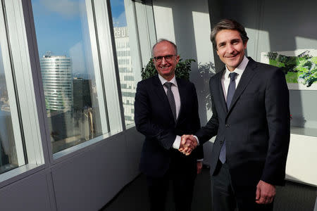 Patrice Caine, Chairman and Chief Executive Officer of Aerospace and defence group Thales, and Philippe Vallee, Chief Executive Officer of chipmaker Gemalto, shake hands before a news conference in Paris, France, December 18, 2017. REUTERS/Philippe Wojazer