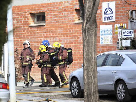 Fire-fighters, some wearing gas masks, leave the Simar chemical plant where an explosion occurred in Igualada near Barcelona February 12, 2015. REUTERS/Stringer