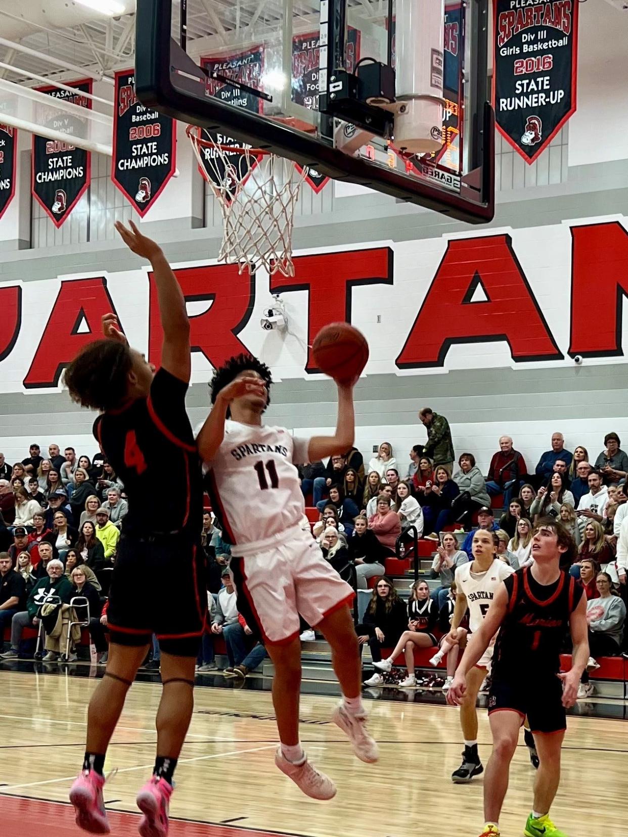 Pleasant's Trey Booker shoots against Marion Harding's Alex Stokes during a Mid Ohio Athletic Conference home boys basketball game Thursday.