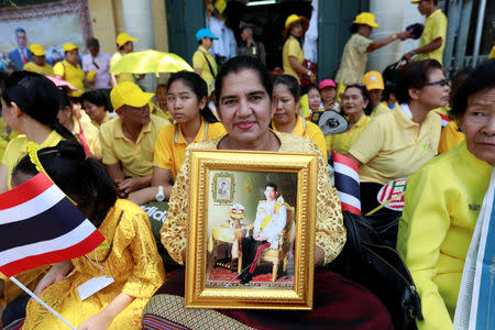 A woman holds a portrait of Thailand's newly crowned King Maha Vajiralongkorn while waiting for a coronation procession in Bangkok, Thailand May 5, 2019. REUTERS/Soe Zeya Tun