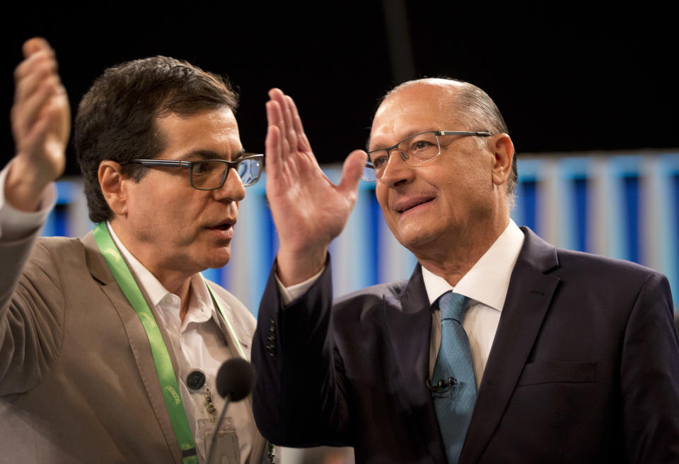 Geraldo Alckmin, presidential candidate of the Social Democratic Party, right, talks with an adviser before a live, televised presidential debate in Rio de Janeiro, Brazil, Thursday, Oct. 4, 2018. Brazil will hold general elections on Oct. 7. (AP Photo/Silvia Izquierdo)
