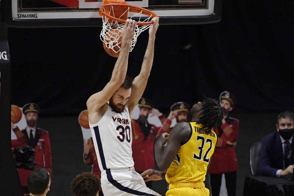 Virginia's Jay Huff dunks as Towson's Charles Thompson defends in the first half of an NCAA college basketball game, Wednesday, Nov. 25, 2020, in Uncasville, Conn. (AP Photo/Jessica Hill)