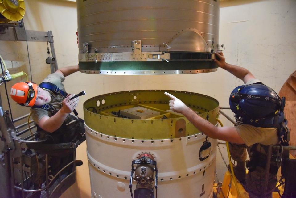 FILE - In this image provided by the U.S. Air Force, Airman 1st Class Jackson Ligon, left, and Senior Airman Jonathan Marinaccio, 341st Missile Maintenance Squadron technicians connect a re-entry system to a spacer on an intercontinental ballistic missile during a Simulated Electronic Launch-Minuteman test Sept. 22, 2020, at a launch facility near Malmstrom Air Force Base in Great Falls, Mont.