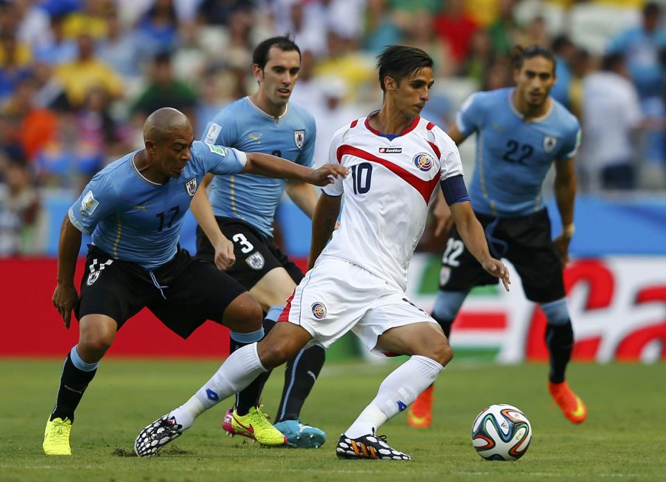 Uruguay's Egidio Arevalo Rios (L) and Costa Rica's Bryan Ruiz fight for the ball during their 2014 World Cup Group D soccer match at the Castelao stadium in Fortaleza June 14, 2014. (Dominic Ebenbichler/Reuters)