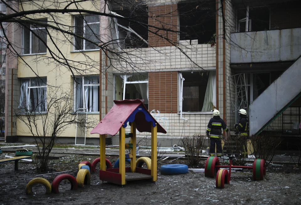 Rescuers stand at the scene where a helicopter crashed on civil infrastructure in Brovary, on the outskirts of Kyiv, Ukraine, Wednesday, Jan. 18, 2023. The chief of Ukraine's National Police says a helicopter crash in a Kyiv suburb has killed 16 people, including Ukraine's interior minister and two children. He said nine of those killed were aboard the emergency services helicopter. (AP Photo/Daniel Cole)