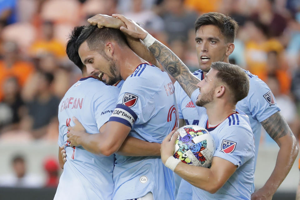 FC Dallas defender Matt Hedges, center, gets hugs and head pats from Marco Farfan, left, Jose Martinez, top right, and Paul Arriola, right, after his goal against the Houston Dynamo during the first half of an MLS soccer match Saturday, July 9, 2022, in Houston. (AP Photo/Michael Wyke)