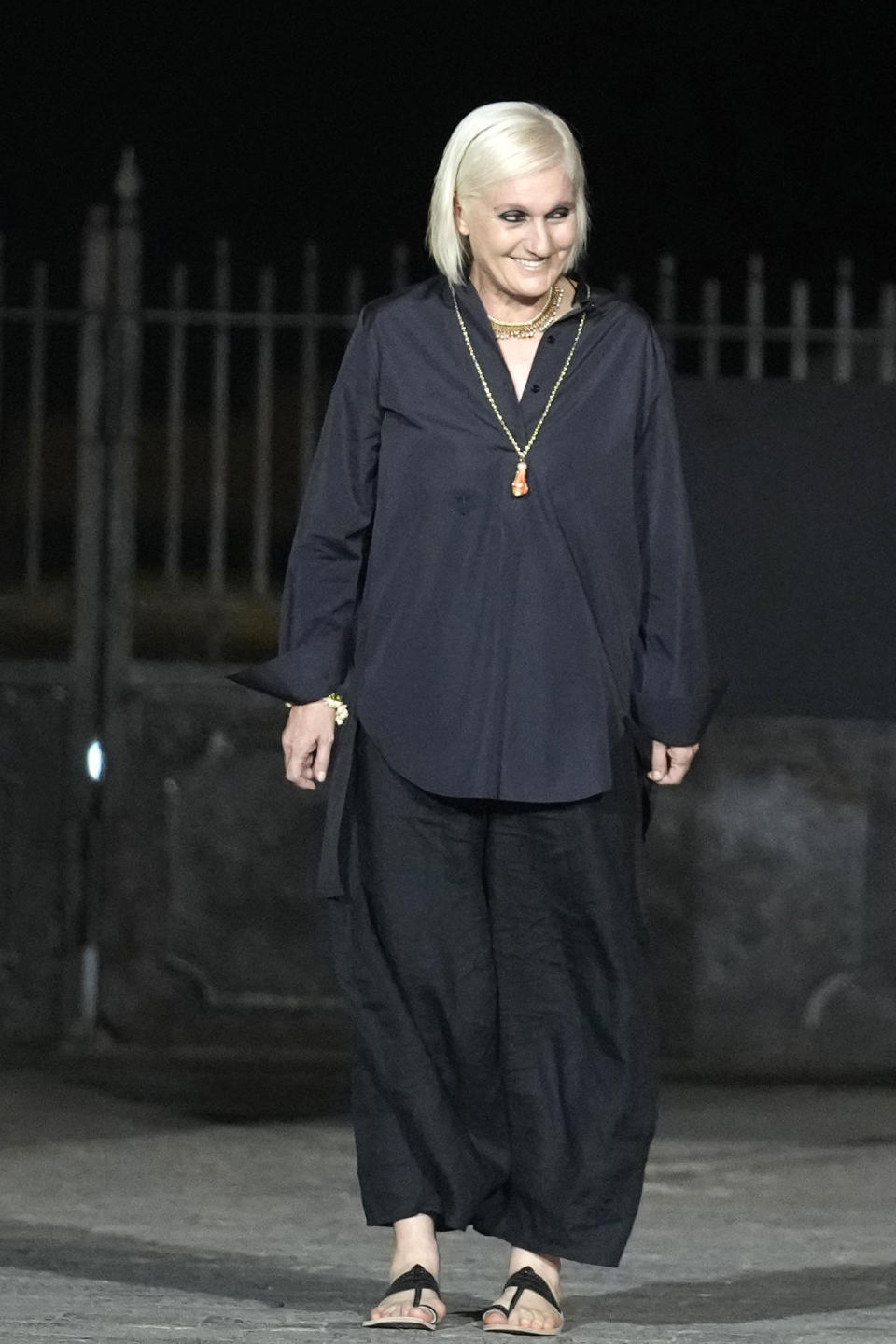Dior's Creative Director Maria Grazia Chiuri acknowledges the crowd at the end of the Dior Pre-Fall 2023 collection at the Gateway of India landmark monument in Mumbai, India, Thursday, March 30, 2023. (AP Photo/Rafiq Maqbool)