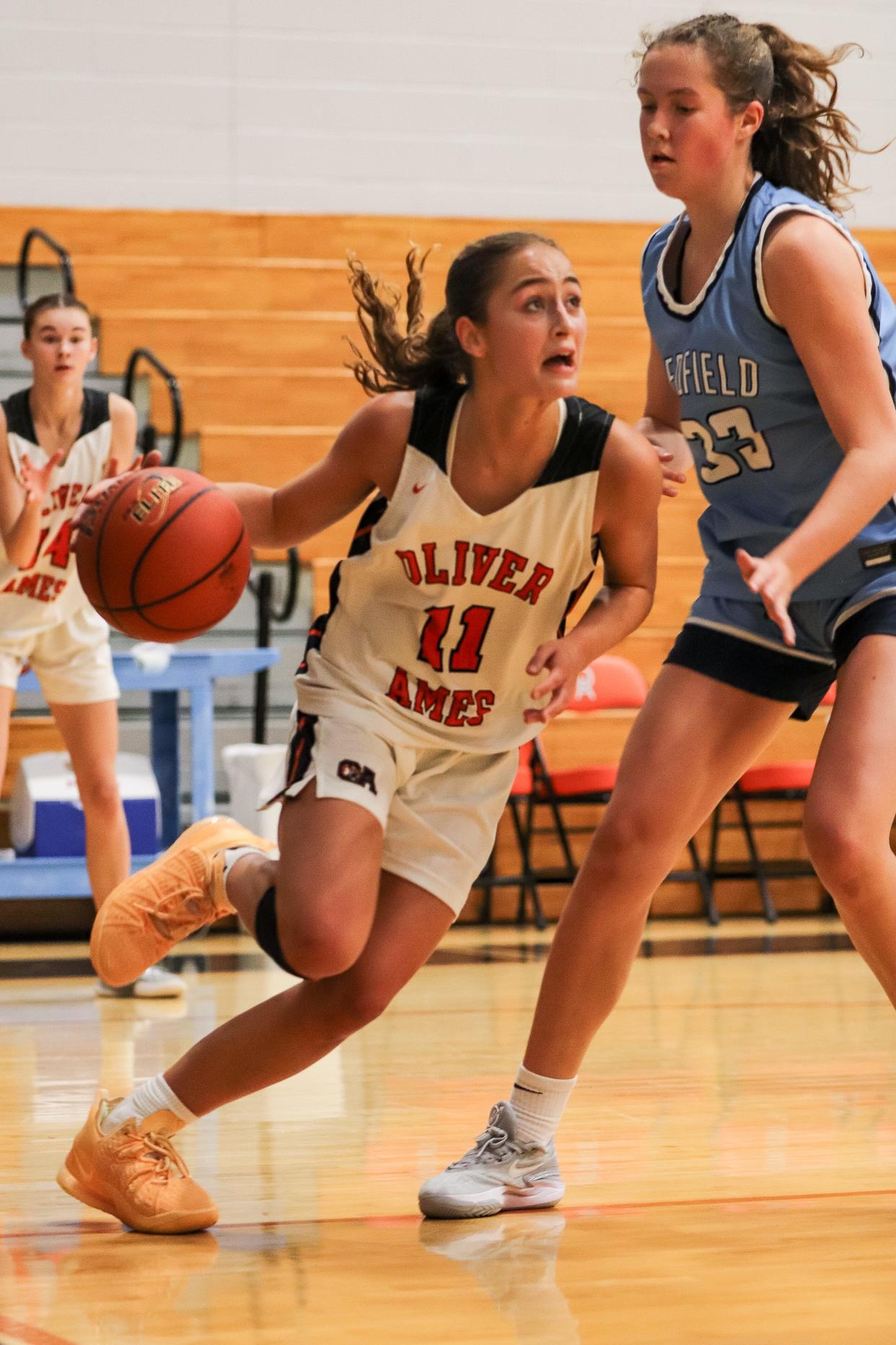 Oliver Ames' Avery Gamble drives past Medfield's Izzy Kittredge during a game at Oliver Ames High School on Friday, Dec. 29, 2023.