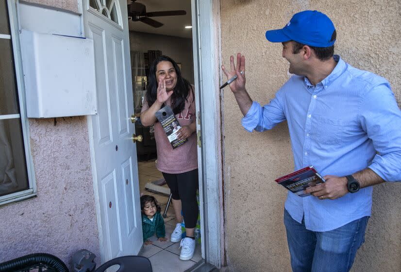 OXNARD, CA-OCTOBER 28, 2022: Matt Jacobs, Republican candidate for election to the U.S. House of Representatives, California 26th Congressional District, waves to Jacqueline Mercado, 28, with her daughter Olivia Solrioi, 1, in front of their home on N St. in Oxnard, while campaigning on October 28, 2022. (Mel Melcon / Los Angeles Times)