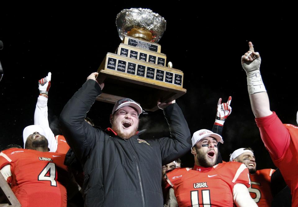 Laval Rouge et Or's Jean-Alexandre Bernier (C) celebrates with teammates Pascal Lochard (L) and Guillaume Rioux after they defeated the Calgary Dinos to win the Vanier Cup University Championship football game in Quebec City, Quebec, November 23, 2013. REUTERS/Mathieu Belanger (CANADA - Tags: SPORT FOOTBALL)