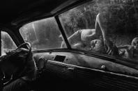 <p>Boys sleep on the hood of a pickup truck on a hot summer day in Stillhouse Hollow, Tenn., 1986. (© Eugene Richards) </p>