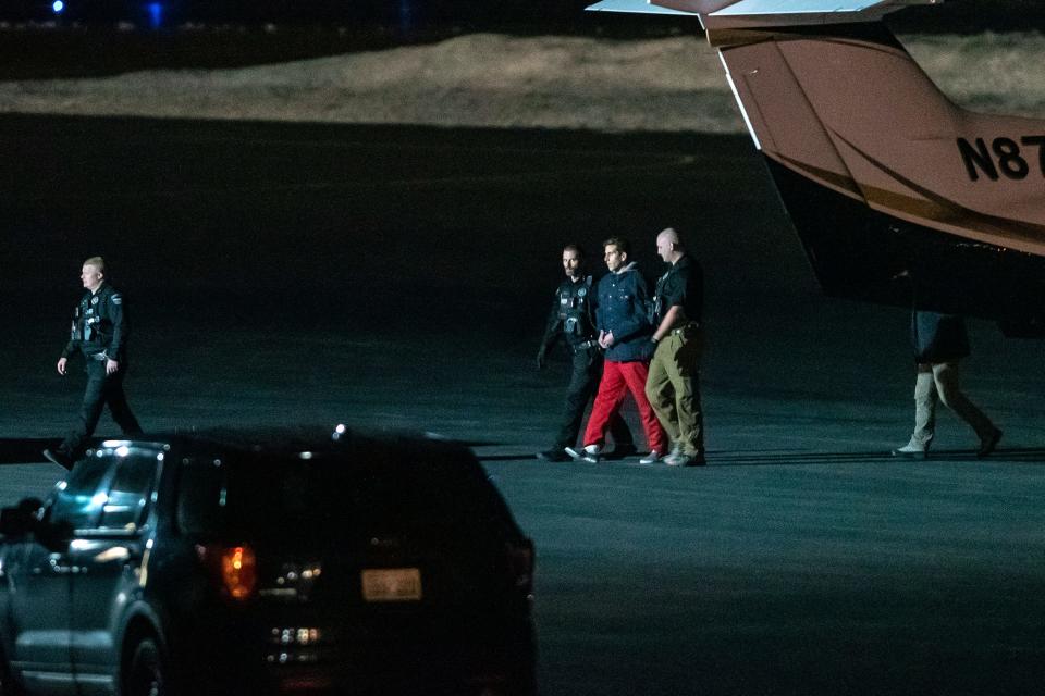 Bryan Kohberger is pictured being escorted by law enforcement after arriving at Pullman-Moscow Regional Airport in Pullman, Washington.