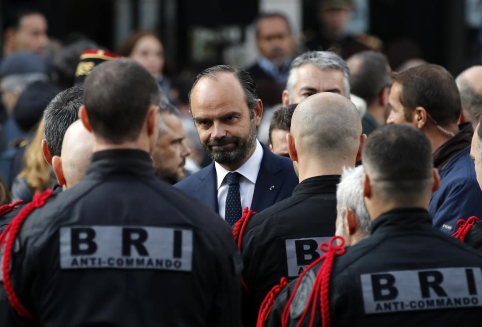 French Prime Minister Edouard Philippe, center, speaks with members of Research and Intervention Brigades (BRI) during a ceremony marking the third anniversary of the Paris attacks of November 2015 in which 130 people were killed, in Paris, Tuesday, Nov. 13, 2018. France's interior minister says French security services have foiled six terror attacks this year, as the country marks three years since gun and bomb attacks in Paris killed 130 people. (AP Photo/Christophe Ena)