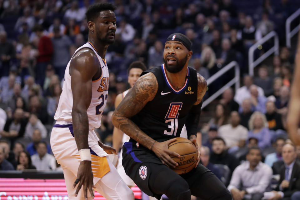 Los Angeles Clippers forward Marcus Morris Sr. (31) looks to shoot over Phoenix Suns center Deandre Ayton (22) during the first half of an NBA basketball game, Wednesday, Feb. 26, 2020, in Phoenix. (AP Photo/Matt York)