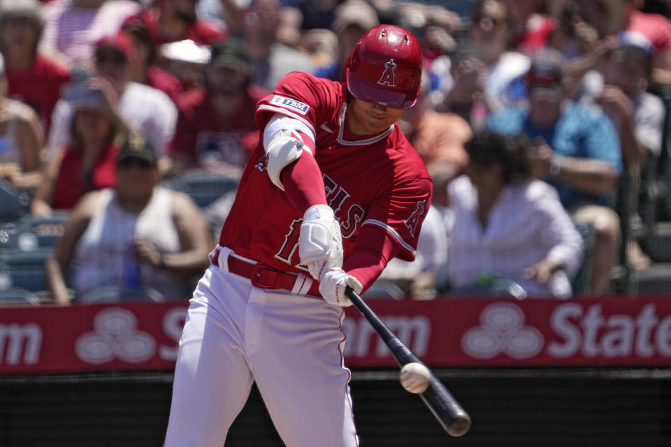 Los Angeles Angels' Shohei Ohtani hits a sacrifice fly during the first inning of a baseball game against the Kansas City Royals Sunday, April 23, 2023, in Anaheim, Calif. Taylor Ward scored on the play. (AP Photo/Mark J. Terrill)