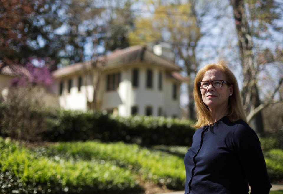 In this March 31, 2014 photo, Laura Mullins, Laura Mullins, a parishioner of Christ the King Cathedral, stands for a photo outside the former residence of Atlanta Archbishop Wilton Gregory, which will now be used as the church's rectory in Atlanta. Gregory apologized for spending $2.2 million on a mansion for his own personal use. The apology came after Pope Francis permanently removed a German bishop for his lavish spending on a renovation project. Mullins arranged a meeting with Gregory in January during which she and nine other Catholics asked him to sell the new mansion. (AP Photo/David Goldman)