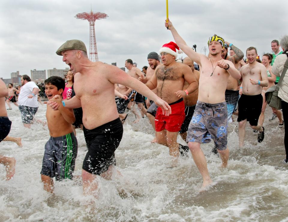 NEW YORK, NY - JANUARY 1: People run into the chilly water as they take part in the Coney Island Polar Bear Club's New Year's Day swim on January 1, 2013 in the Coney Island neighborhood of the Brooklyn borough of New York City. The annual event attracts hundreds who brave the icy Atlantic waters and temperatures in the upper 30's as a way to celebrate the first day of the new year. (Photo by Monika Graff/Getty Images)