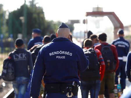 Police escort migrants without valid tickets from a train bound for Munich, at the railway station in Hegyeshalom, Hungary, September 7, 2015. REUTERS/Leonhard Foeger