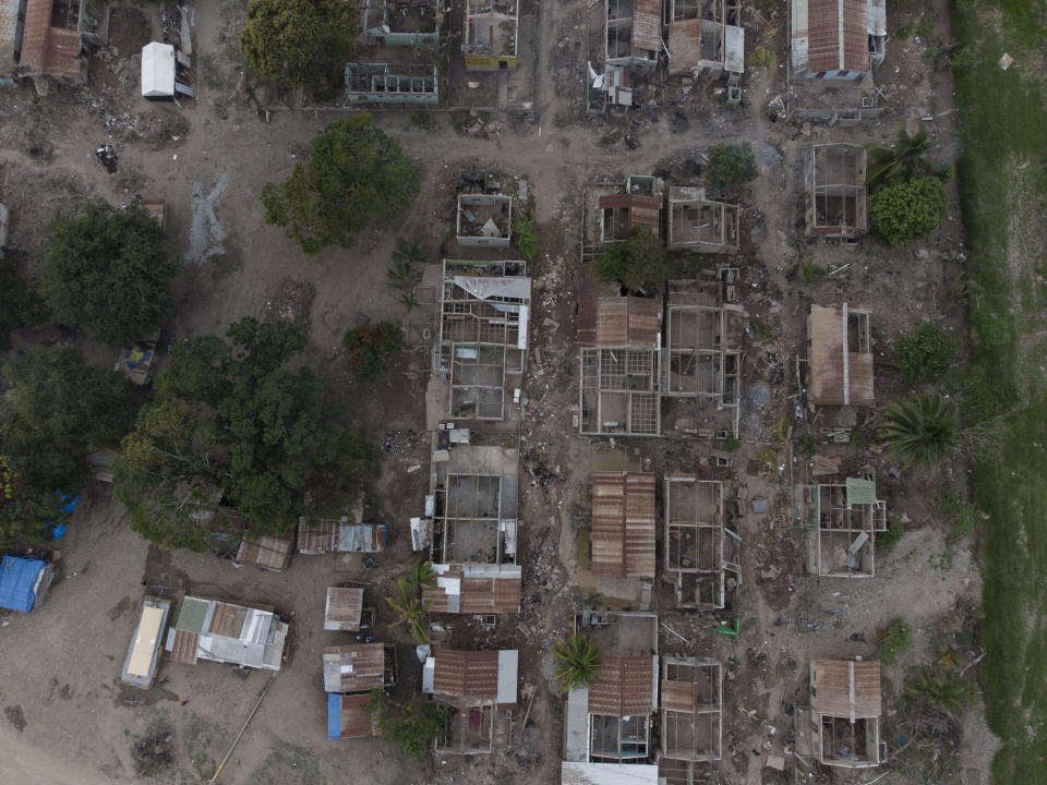The shells of homes lay in ruins in La Samaritana village after last year's hurricanes Eta and Iota destroyed the area in La Lima, on the outskirts of San Pedro Sula, Honduras, Wednesday, Jan. 13, 2021. Those who lived here are now in nearby temporary shacks made of wood and zink sheets. (AP Photo/Moises Castillo)