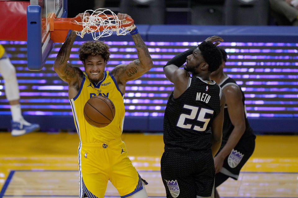 Golden State Warriors guard Kelly Oubre Jr. (12) dunks against Sacramento Kings forward Chimezie Metu (25) during the first half of an NBA basketball game on Sunday, April 25, 2021, in San Francisco. (AP Photo/Tony Avelar)