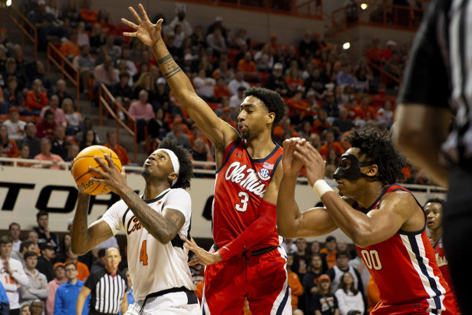 Mississippi's Myles Burns (3) and Jayveous McKinnis (00) guard against Oklahoma State's Woody Newton (4) in the first half of an NCAA college basketball game in Stillwater, Okla., Saturday, Jan. 28, 2023. (AP Photo/Mitch Alcala)