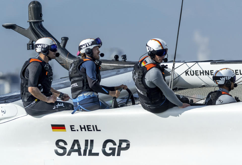 In this photo provided by SailGP, Sebastian Vettel, four-time Formula One world champion and investor of Germany SailGP Team, takes control of the wheel onboard the Germany SailGP Team F50 catamaran as he joins the Germany SailGP Team for a sixth sailor experience on Race Day 1 of the Oracle Los Angeles Sail Grand Prix at the Port of Los Angeles, Saturday, July 22, 2023. (Simon Bruty/SailGP via AP)