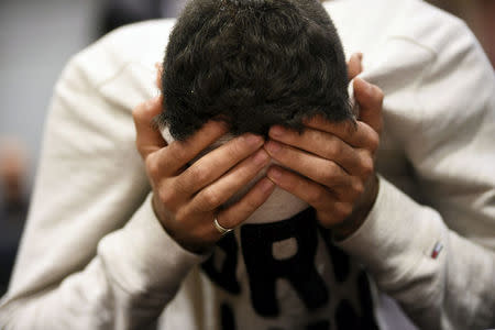 The 18-year-old Moroccan Ilyas Berrouh, covers his face during the initial remand hearing of suspects of killing two people and attempting to kill eight others with terrorist intent (with reasonable doubt) in Turku last week, at the Southwest Finland District Court in Turku, Finland, August 22, 2017. LEHTIKUVA / Martti Kainulainen via REUTERS