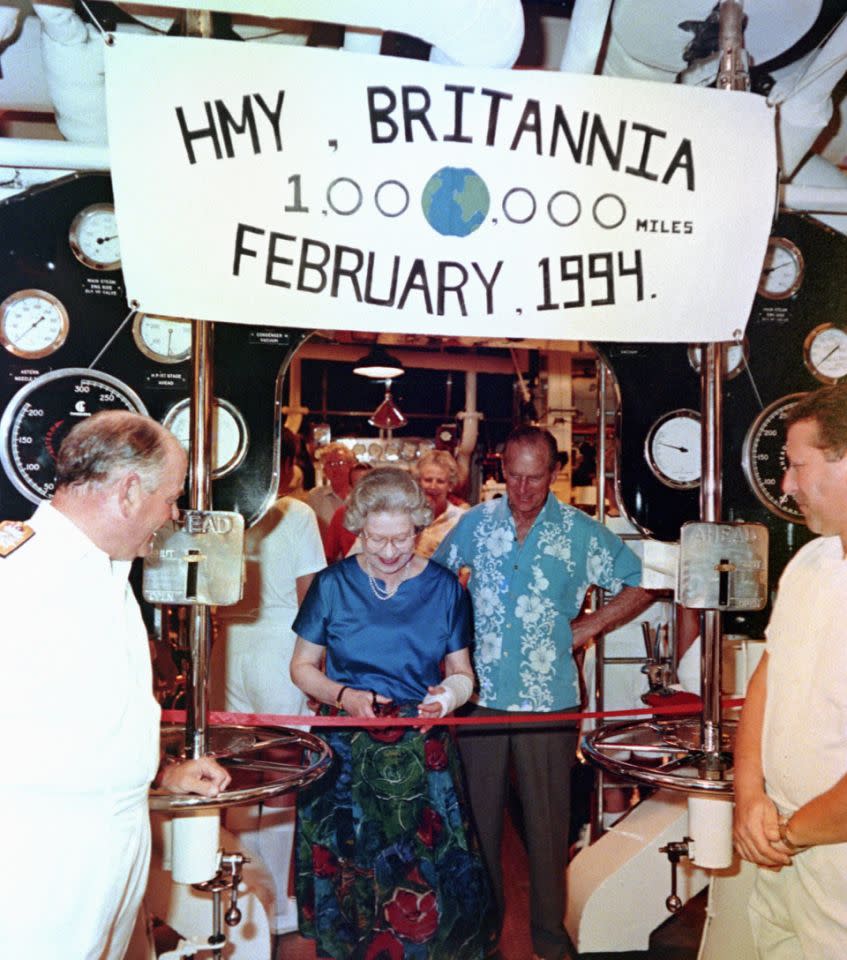 <p>Her Majesty Queen Elizabeth smiles as she cuts a ribbon in the engine of the Royal Yacht Britannia, to mark the ship’s one millionth mile on the same engine. (PA Archive) </p>