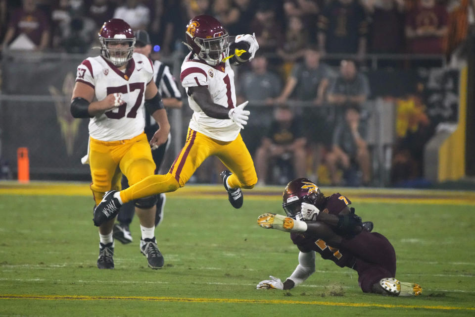 Southern California wide receiver Zachariah Branch (1) leaps over Arizona State defensive back Shamari Simmons during the first half of an NCAA college football game Saturday, Sept. 23, 2023, in Tempe, Ariz. (AP Photo/Rick Scuteri)