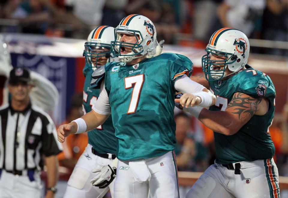 In this 2011 photo, Miami Dolphins quarterback Chad Henne (7) celebrates a touchdown run with Mike Pouncey, left, and Jake Long, right.