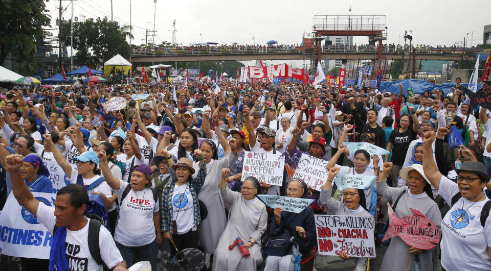Protesters march under the rain towards the Philippine Congress to protest the 4th State of the Nation (SONA) address by President Rodrigo Duterte Monday, July 22, 2019 in suburban Quezon city, northeast of Manila, Philippines. Duterte is facing criticisms about his alleged closeness with China as well as the thousands of killings in his so-called war on drugs. (AP Photo/Bullit Marquez)