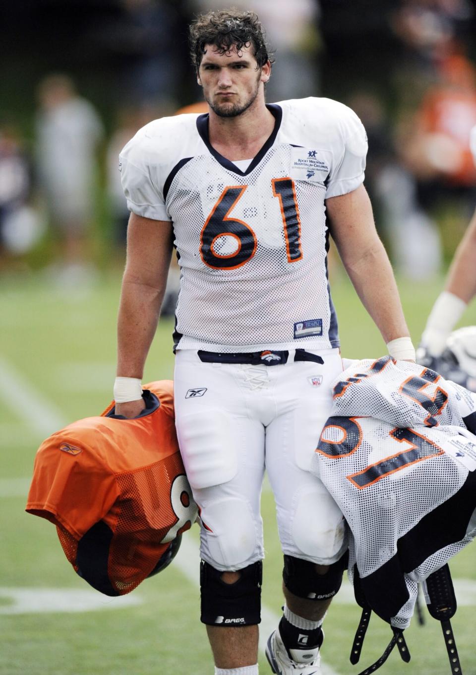 Denver Broncos rookie lineman Paul Duncan carries teammates' pads off the field following NFL football training camp in Englewood, Colo., Monday, Aug. 2, 2010. (AP Photo/Jack Dempsey)