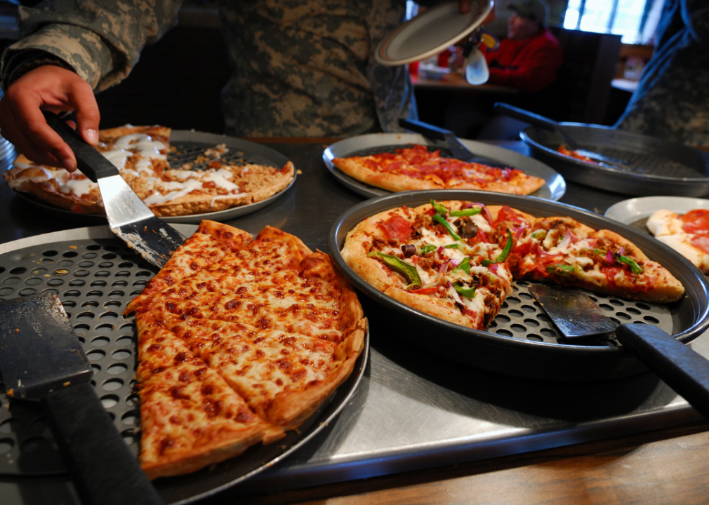 Various types of pizzas on a buffet.