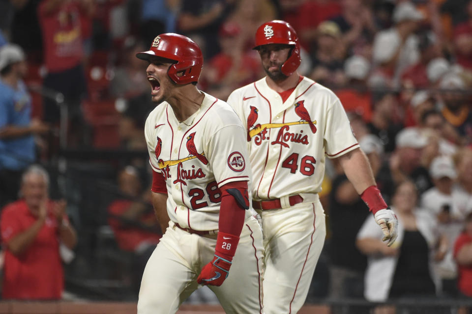 St. Louis Cardinals' Nolan Arenado, left, reacts after hitting a two-run home run during the eighth inning of a baseball game against the Cincinnati Reds on Saturday, Sept. 11, 2021, in St. Louis. (AP Photo/Joe Puetz)