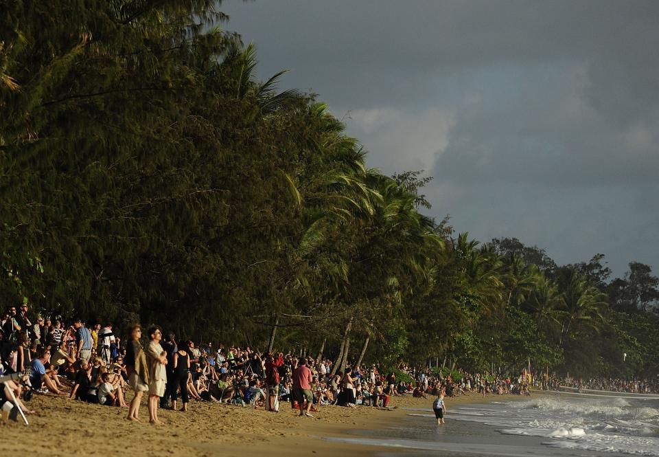 PALM COVE, AUSTRALIA - NOVEMBER 14: Spectators line the beach to view the total solar eclipse on November 14, 2012 in Palm Cove, Australia. Thousands of eclipse-watchers have gathered in part of North Queensland to enjoy the solar eclipse, the first in Australia in a decade. (Photo by Ian Hitchcock/Getty Images)