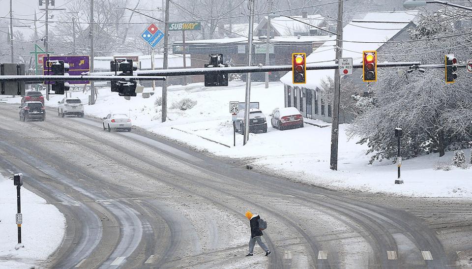 An Ashland University student is seen crossing Claremont Avenue at College Avenue as the snow falls Wednesday morning, Jan. 25, 2023. TOM E. PUSKAR/ASHLAND TIMES-GAZETTE