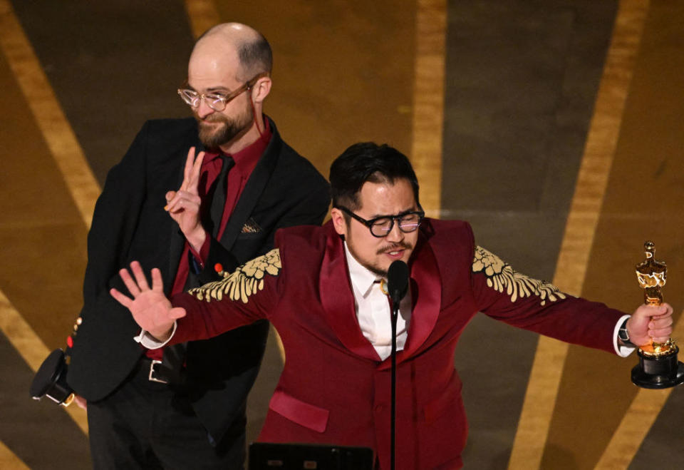 Daniel Scheinert and Daniel Kwan accept the Oscar for Best Original Screenplay for "Everything Everywhere All at Once" onstage