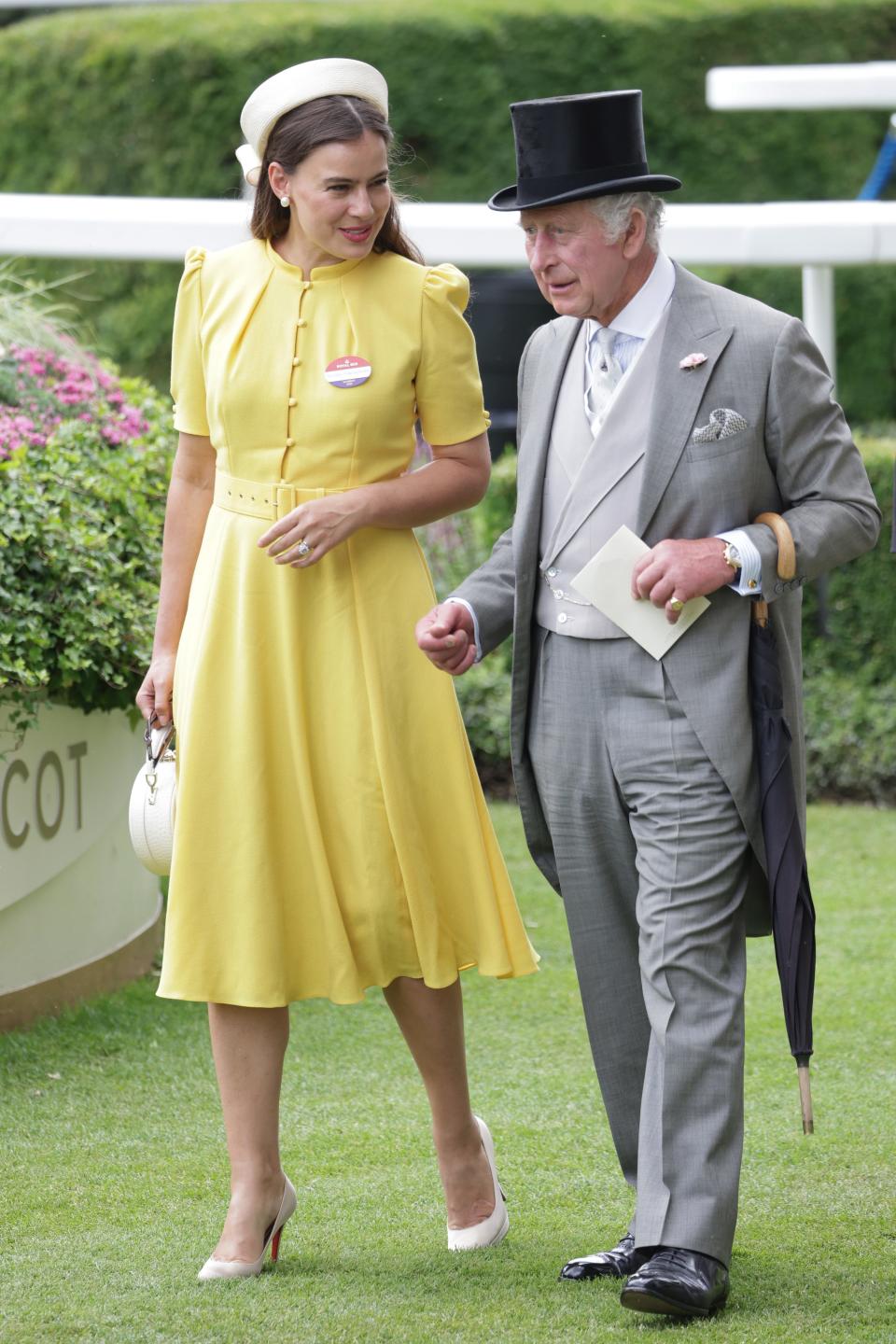Lady Sophie Winkleman wearing a bright yellow dress while walking with King Charles III.