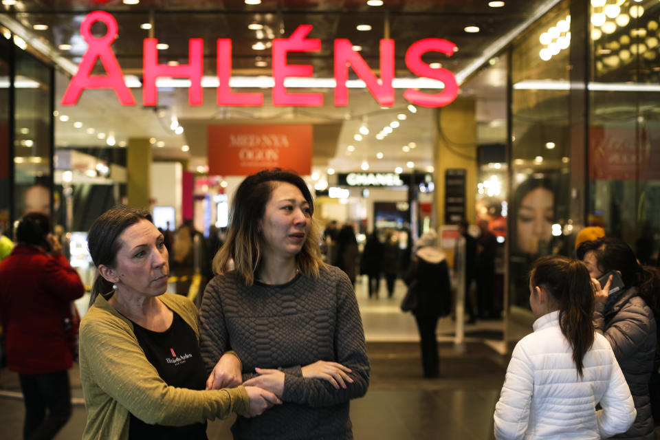 People exit and enter the reopened department store Ahlens in Stockholm, Sweden, Monday, April 10, 2017. Swedes questioned their country's welcoming immigration policies with pride and pain after learning that an asylum-seeker from Uzbekistan was allegedly behind the truck rampage that killed four people, Stockholm's deadliest extremist attack in years. (AP Photo/Markus Schreiber)