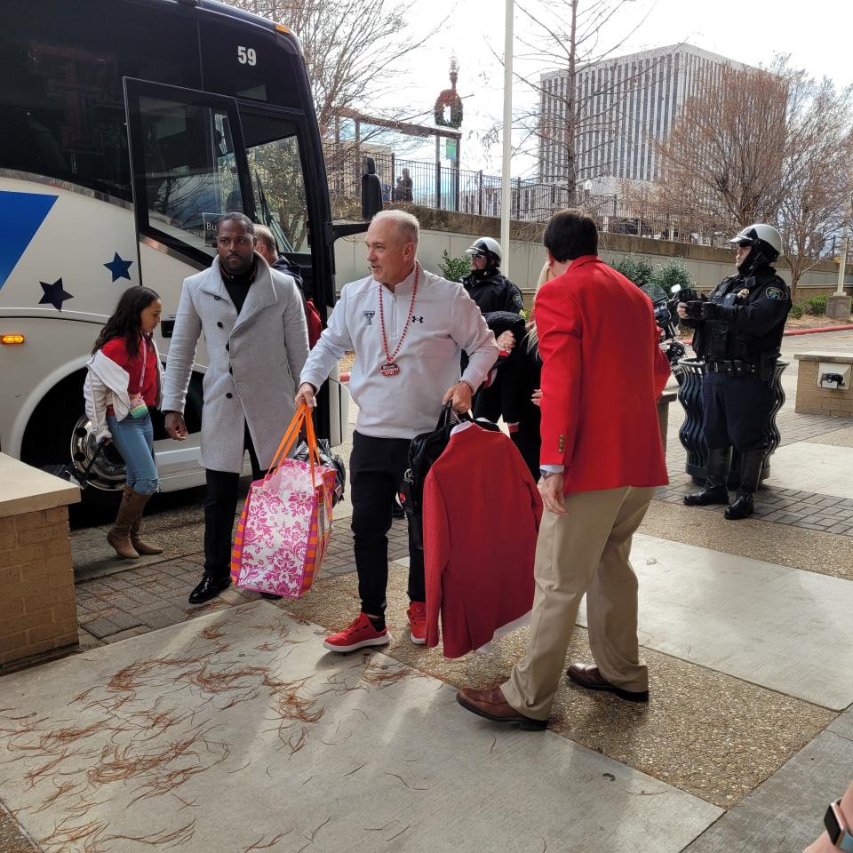 Texas Tech football coach Joey McGuire, center, and associate athletics director for football administration Antonio Huffman, left, arrive at the team hotel in Shreveport, Louisiana, on Wednesday to continue preparation for the Independence Bowl on Saturday.