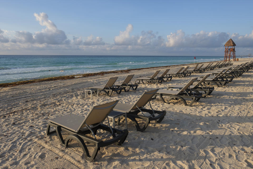 Lounge chairs fill an empty beach in Cancun, Mexico, Thursday, June 11, 2020. An irony of the coronavirus pandemic is that the idyllic beach vacation in Mexico in the brochures really does exist now: the white sand beaches are sparkling clean and empty on the Caribbean coast. (AP Photo/Victor Ruiz)