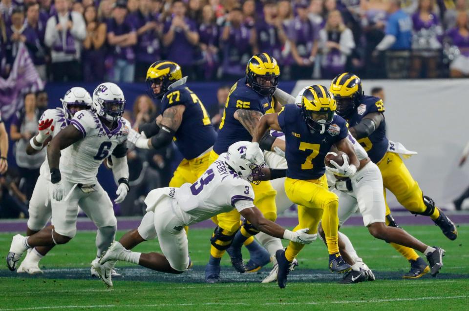 Michigan running back Donovan Edwards slips past TCU safety Mark Perry in the first quarter of the Fiesta Bowl on Saturday, Dec. 31, 2022, in Glendale, Arizona.