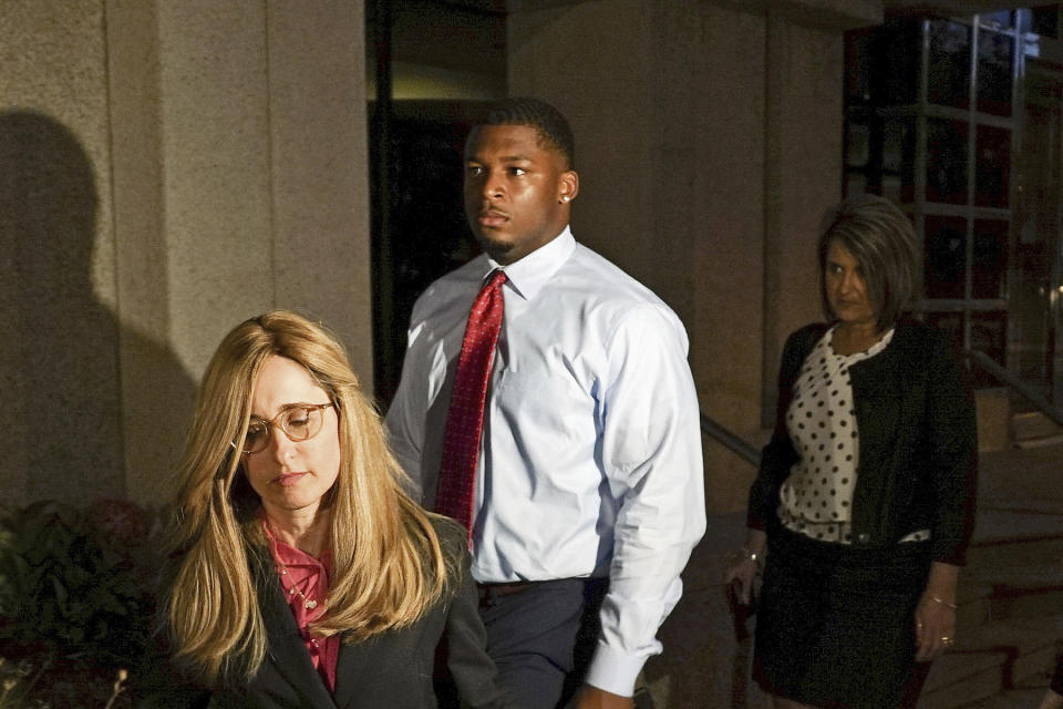 FILE – In this Sept. 14, 2017 file photo, Ma’lik Richmond, center, of Steubenville, Ohio, and his attorney Susan Stone, left, walk out of U.S. District Court in Youngstown, Ohio. In a deal announced Monday, Oct. 2, 2017, Youngstown State University has agreed to settle a federal lawsuit with Richmond, a football player convicted of rape as a teen who sued after the school allowed him to join the team and then told him he couldn’t play this season. (AP Photo/Dake Kang, File)