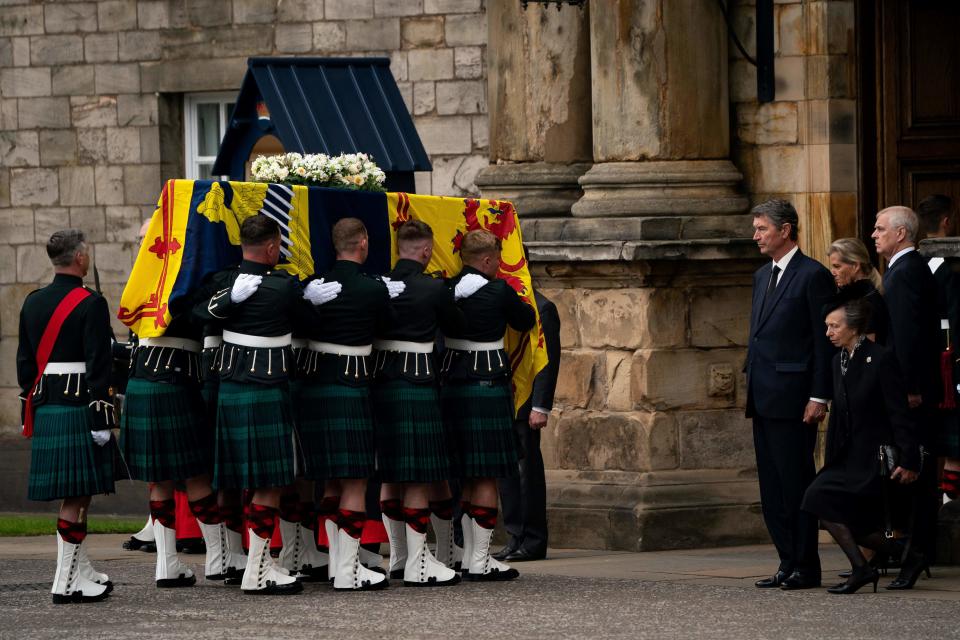 Vice Admiral Timothy Laurence (4R), Britain's Sophie, Countess of Wessex (2R) and Britain's Prince Andrew, Duke of York (R) stands as Britain's Princess Anne, the Princess Royal curtseys to the coffin of Queen Elizabeth II, draped with the Royal Standard of Scotland, as it is carried in to the Palace of Holyroodhouse, in Edinburgh on September 11, 2022. - The coffin carrying the body of Queen Elizabeth II left her beloved Balmoral Castle on Sunday, beginning a six-hour journey to the Scottish capital of Edinburgh. (Photo by Aaron Chown / POOL / AFP) (Photo by AARON CHOWN/POOL/AFP via Getty Images)