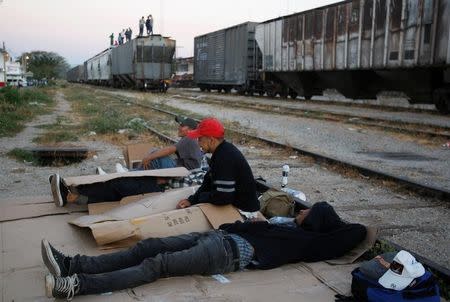 Central American migrants rest next to the train tracks while waiting for the freight train "La Bestia", or the Beast, to travel to north Mexico to reach and cross the U.S. border, in Arriaga in the state of Chiapas January 10, 2012. REUTERS/Jorge Luis Plata/File Photo