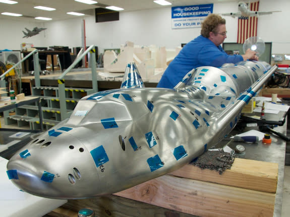 The Dream Chaser model with its Atlas V launch vehicle is undergoing final preparations at the Aerospace Composite Model Development Section's workshop for buffet tests at the Transonic Dynamics Tunnel at NASA Langley. Image released May 7, 201