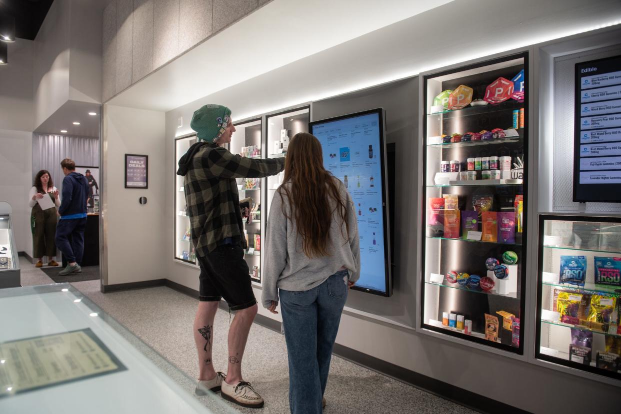 Brett Geiger of Webberville, left, shops with Pure Options budtender Kenna Preadmore, Wednesday, April 17, 2024, at the chain's Frandor location. The store is hosting a '420 Block Party' with live music and store specials through April 20th.