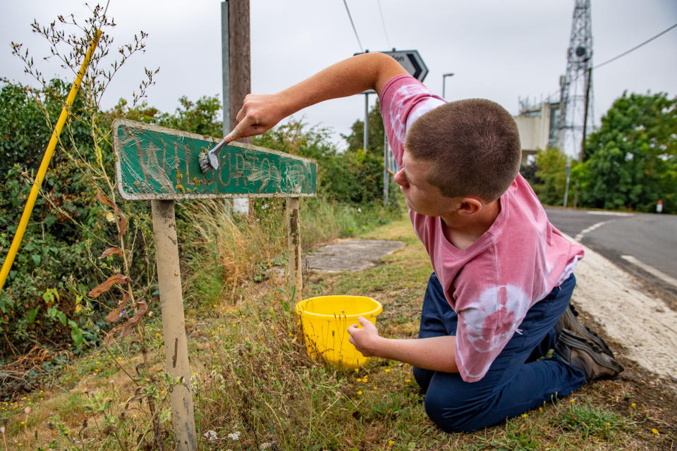 A teenage boy annoyed by road signs left dirty and hedges overgrown during lockdown has become a local hero after going on a mission to clean them all up. Joseph Beer, 15, noticed dozens of neglected street signs and hedgerows whilst out on his daily walks with mum Lisa, 52. He soon decided he wanted to clean up the streets - and with the help of dad Mark, 56, he rigged up a trailer to fix to the back of his bike, and started peddling around the streets near his house. Almost every day, Joseph, from Chatteris, Cambs., has headed off on his bike, towing a bucket of soapy water, some sponges, and garden tools, including hedgecutters and a rake, in the trailer.

His efforts have seen him clean up street name signs that have been left almost unreadable due to moss growing over them, such as Wilburton Road in nearby Ely.