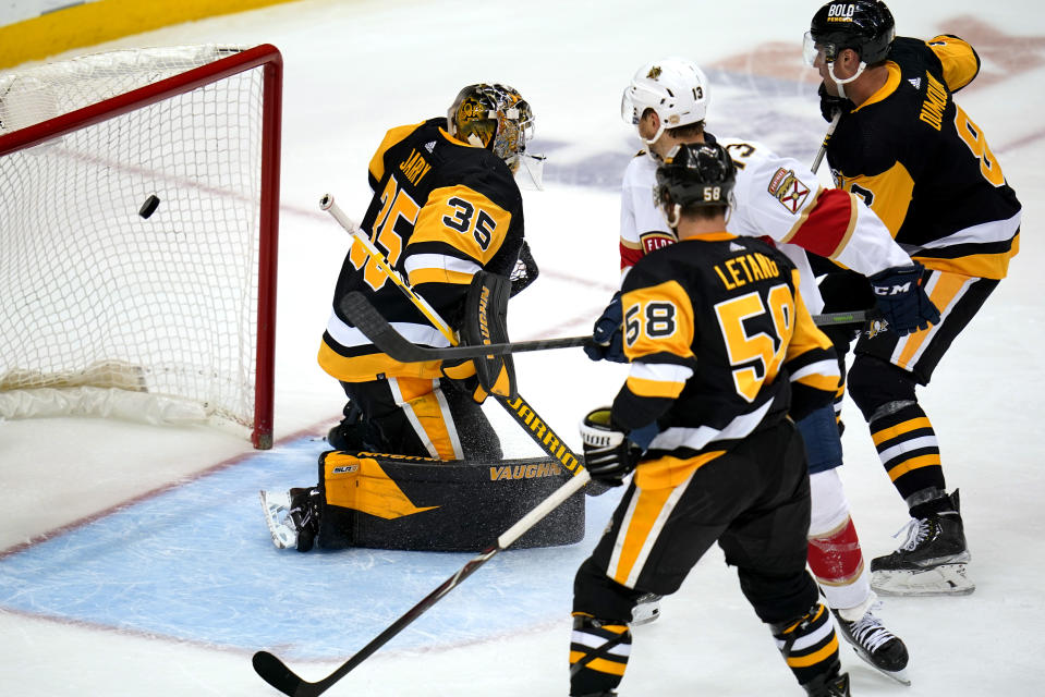 Florida Panthers' Sam Reinhart (13) swats the puck out of the air and into the net behind Pittsburgh Penguins goaltender Tristan Jarry (35) for a goal during the first period of an NHL hockey game in Pittsburgh, Tuesday, March 8, 2022. (AP Photo/Gene J. Puskar)